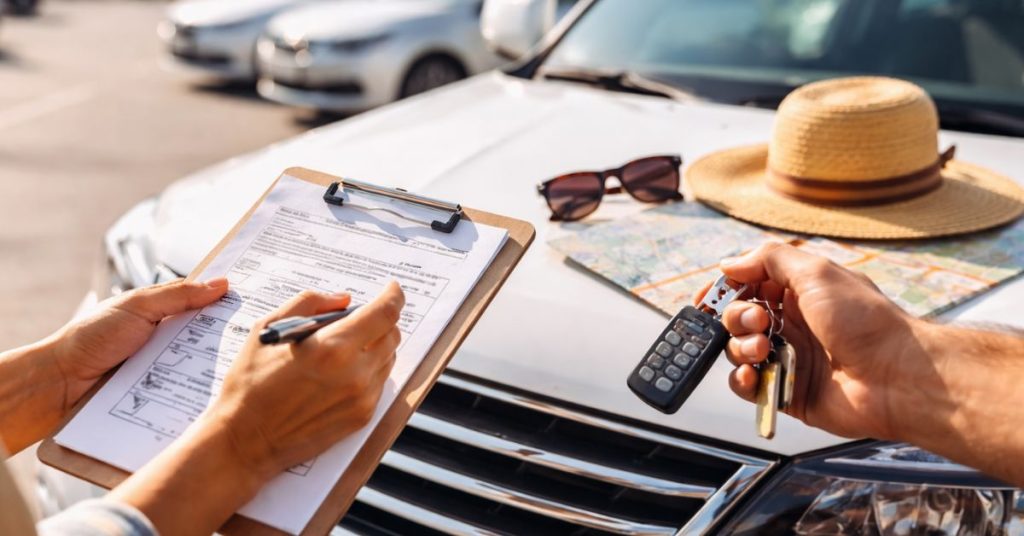 Location de voiture conseil : vérification du véhicule avec checklist et clés avant la prise en charge sur un parking de location.