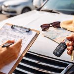 Location de voiture conseil : vérification du véhicule avec checklist et clés avant la prise en charge sur un parking de location.