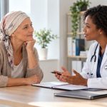 Patiente atteinte d’un cancer échangeant avec une médecin lors d’une consultation de suivi pendant ou après son traitement.